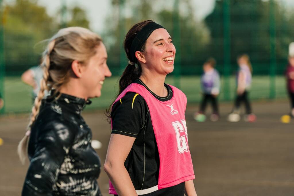 Women smiling at netball training - University Membership